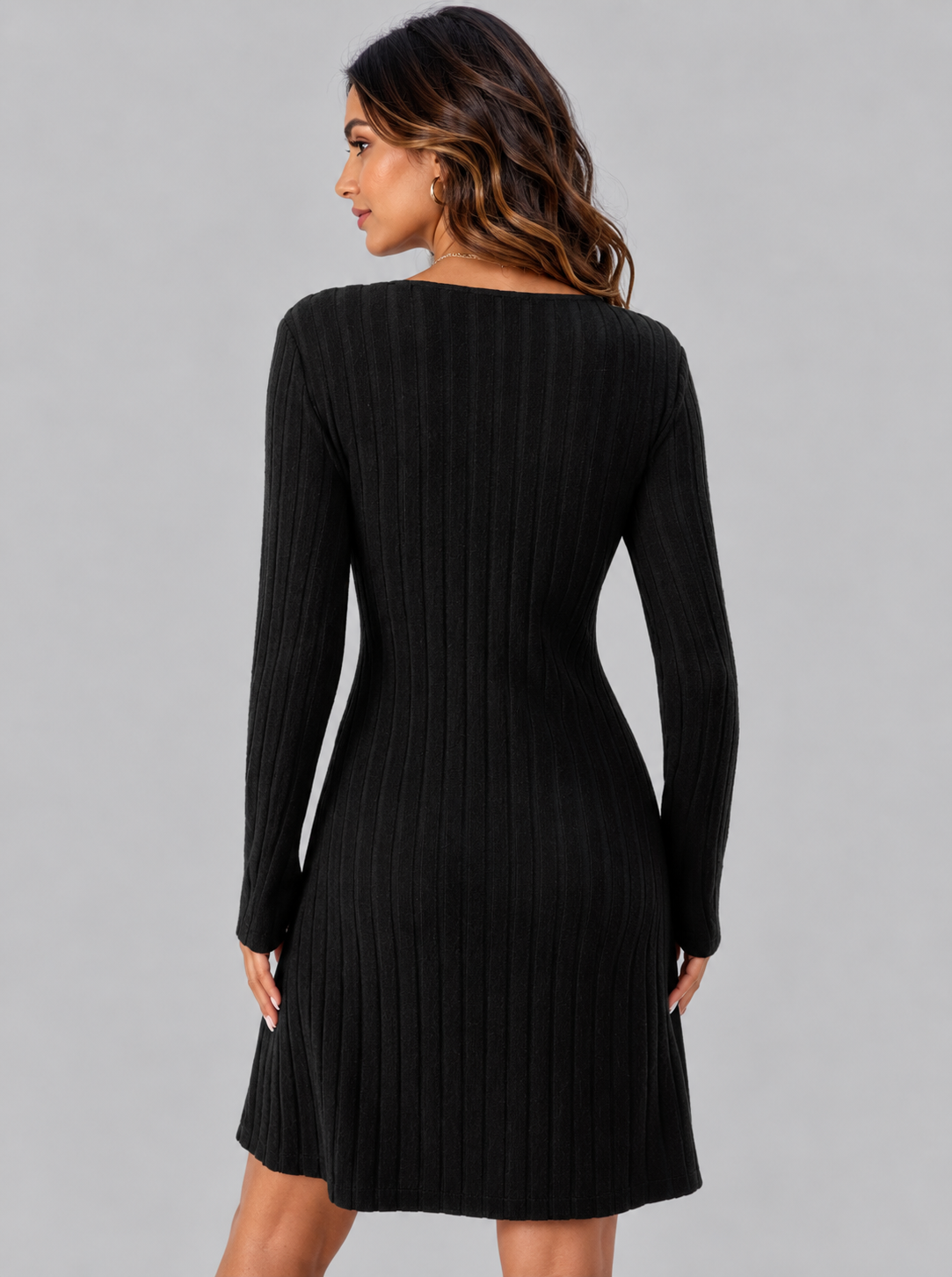 A woman wearing a black long-sleeve ribbed knit dress, shown from the back against a solid gray studio background.