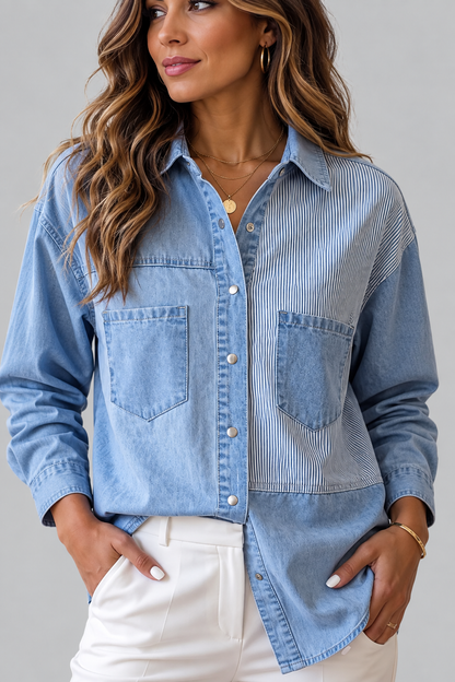 A woman wearing a light blue patchwork button-up shirt with denim and fine stripe panels, paired with white pants, against a neutral gray background.